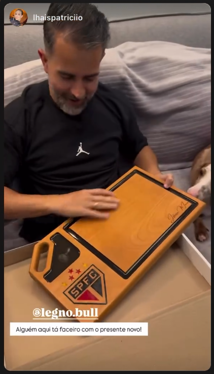 Cliente abrindo a caixa com a tábua gravada com o escudo do São Paulo
